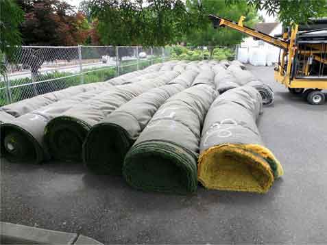 Rolls of synthetic turf after removal
